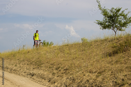 Man on the old bike is traveling across the steppe.