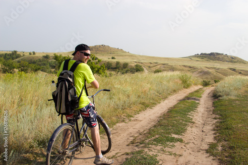Man on the old bike is traveling across the steppe.