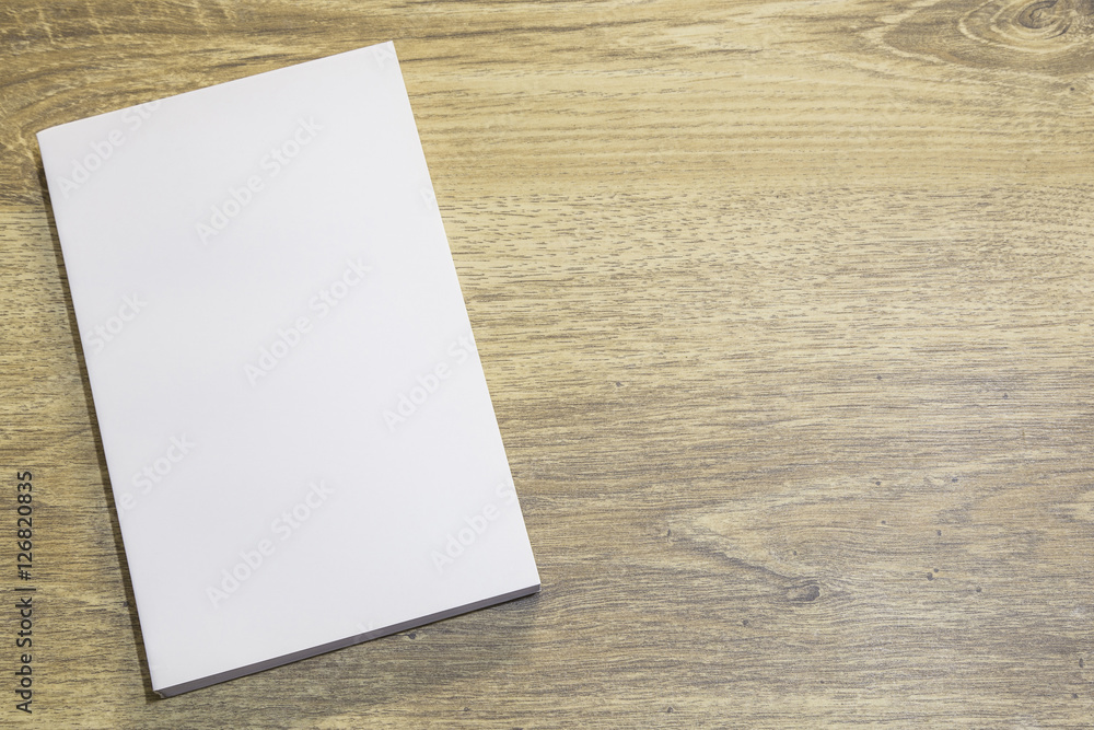 Real 3D paperback white book on a wood background Real 3D paperback white book on a wood background