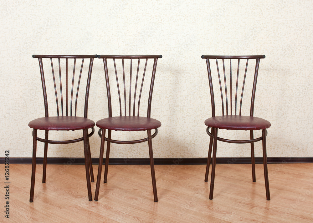 Three of the same chair against the wall Three of the same chair against the wall