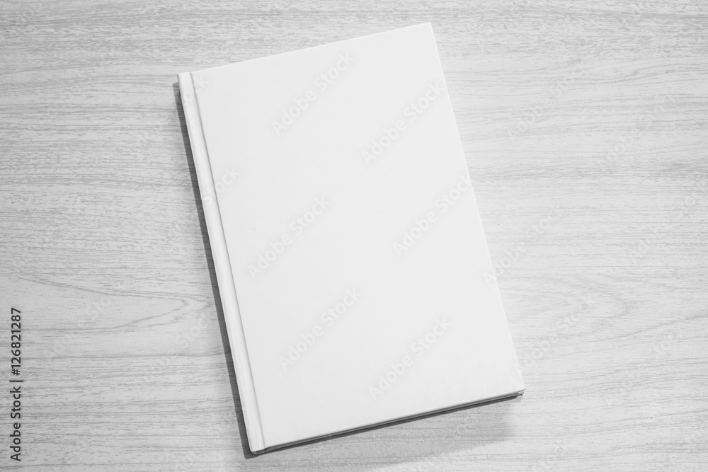 Obraz premium Real 3D hardcover white book on a wood background
