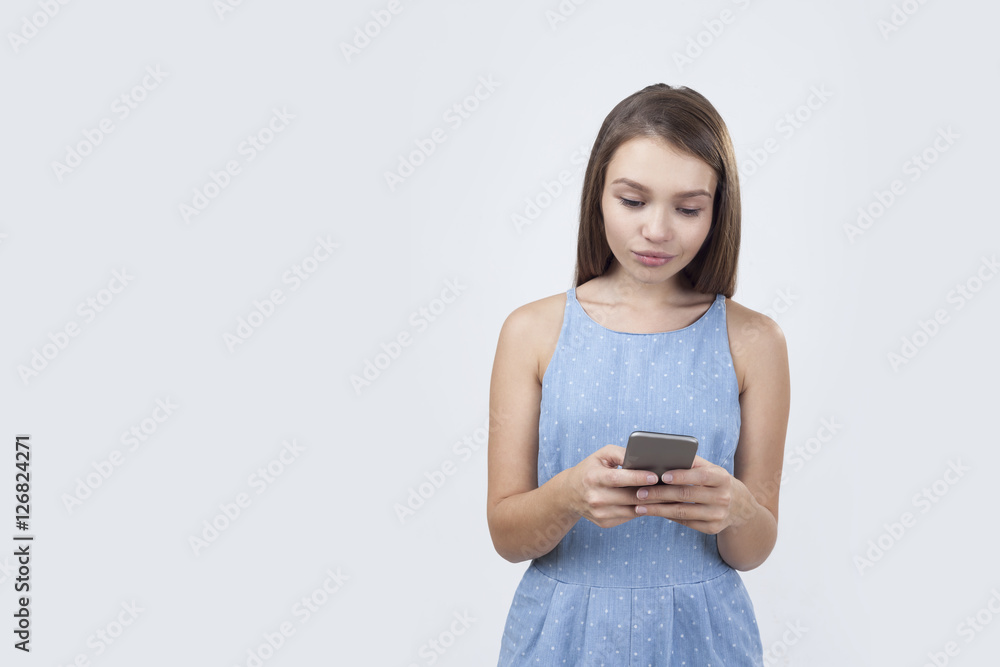 Calm woman in blue dress with a cell phone Calm woman in blue dress with a cell phone