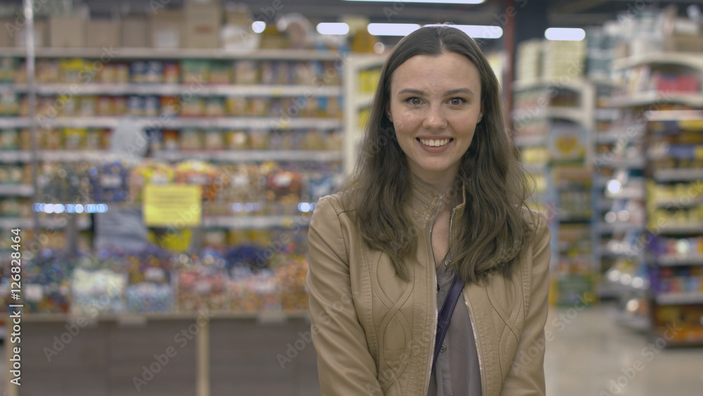Happy girl standing in the supermarket