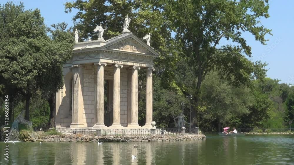 Villa Borghese, Rome, Italy, view of Esculapio temple with pond and tourists on rowing boat. Beautiful historical park in Rome. Travel, tourism destination, Italian history, summer holidays in Europe Villa Borghese, Rome, Italy, view of Esculapio temple with pond and tourists on rowing boat. Beautiful historical park in Rome. Travel, tourism destination, Italian history, summer holidays in Europe