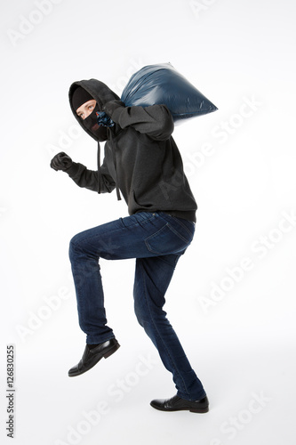 Thief slinking with blue bag © Sergey