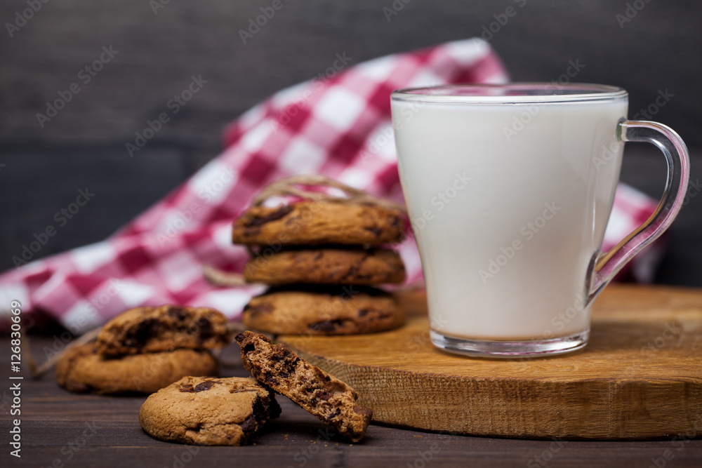 Transparent glass of milk and cookies with chocolate. On a wooden table. Healthy diet. Transparent glass of milk and cookies with chocolate. On a wooden table. Healthy diet.