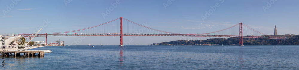 Lisbon, Portugal. The 25 de Abril bridge spanning over the Tagus River. On the right it’s seen the famous the Cristo-Rei Sanctuary.