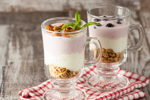 Fresh yogurt with granola and muesli, fresh berries and almonds nuts. Healthy morning breakfast of smoothie.