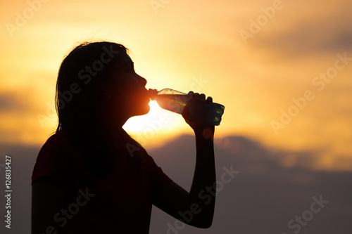 Silhouette of woman with sport drink