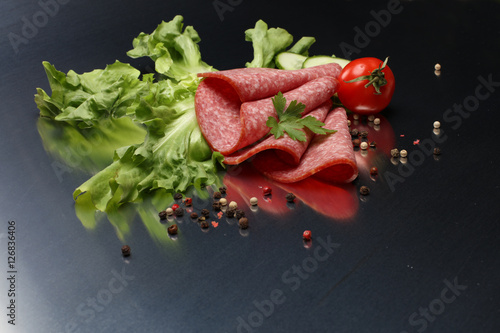 Different Italian ham and salami with herbs