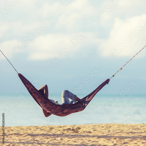 Woman an using a smartphone while relaxing in a hammock © Glebstock