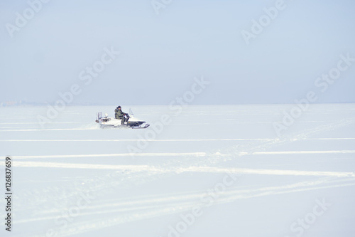 A man rides a snowmobile. Winter. A lot of snow.