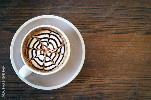 Mocha coffee (also called Caffe Mocha) with wooden saucer. Interior coffee shop. Main ingredients of mocha is chocolate, espresso, hot milk. (vintage tone) photo