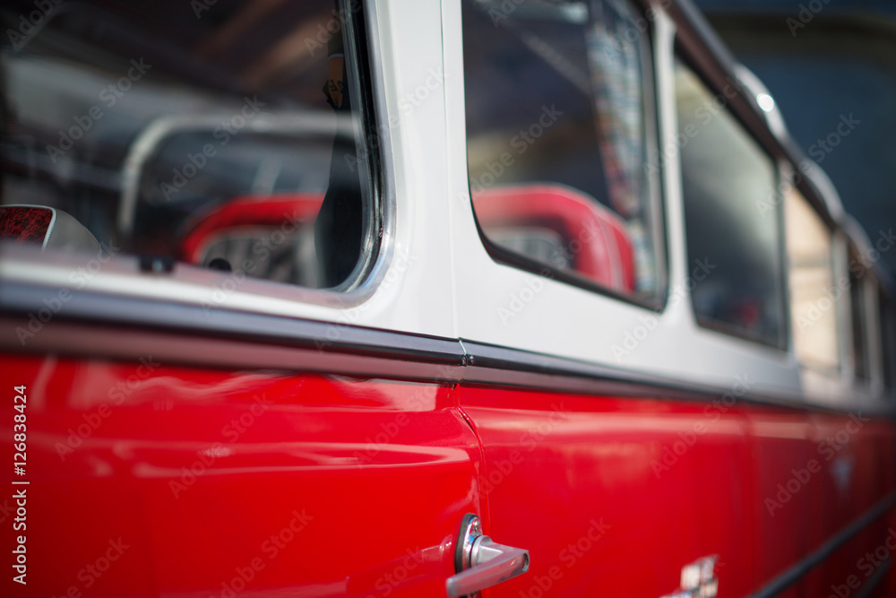 Part of red retro bus with passenger seats.