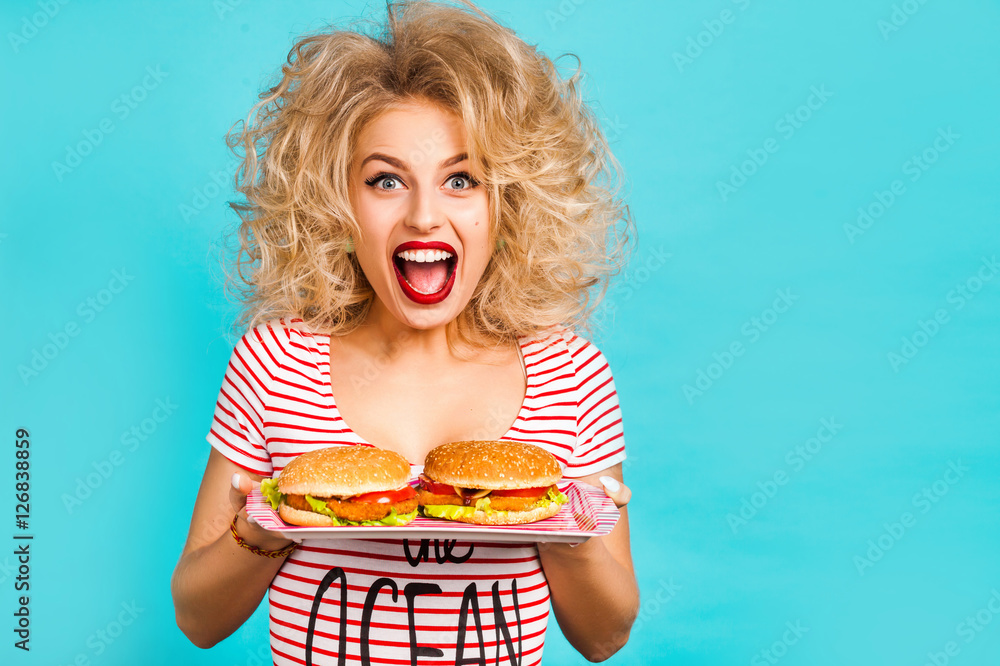 Studio fashion portrait of a beautiful funny girl on the turquoise background, blonde holding a tray of burgers, joyful shouts, laughs, crazy emotions, curly hair, perfect makeup, hairstyle, fast food Studio fashion portrait of a beautiful funny girl on the turquoise background, blonde holding a tray of burgers, joyful shouts, laughs, crazy emotions, curly hair, perfect makeup, hairstyle, fast food