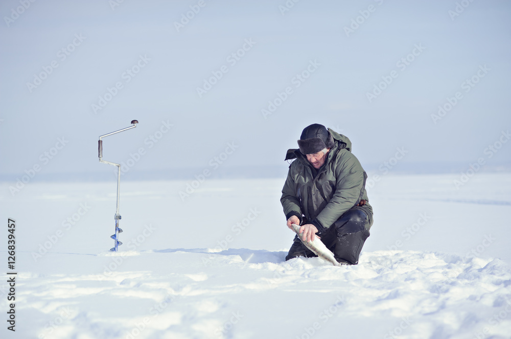 Fisherman in winter on the ice caught fish.