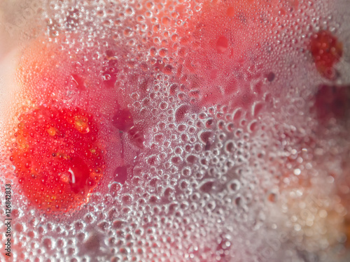 Drops on plastic bucket and strawberries