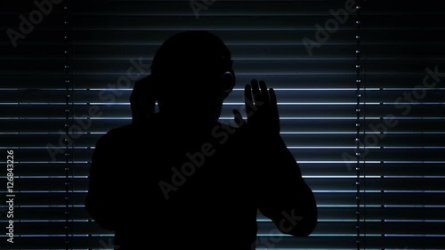 silhouette guy wiretapping and pulling down metal window blinds to spy on his neighbor. Blocking the camera at the end.
