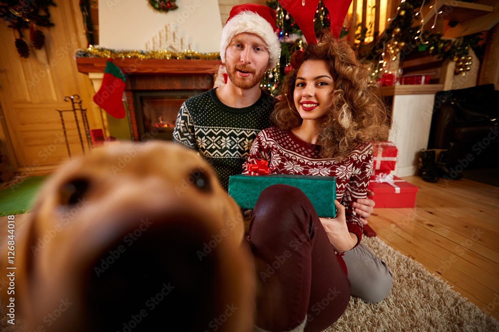 Christmas couple enjoying with dog. Stock-Foto | Adobe Stock