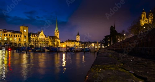 Zurich, Switzerland - view over river Limmat with Church Fraumnster, and Church St. Peter from Utoquai at night - Timelapse with zoom in - March 2016 photo