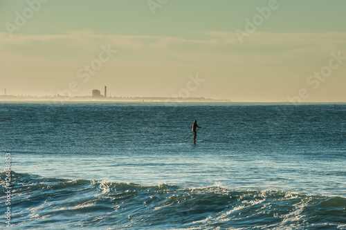 Stand up paddler taking advantage of lull between sets of waves in Ventura. © motionshooter