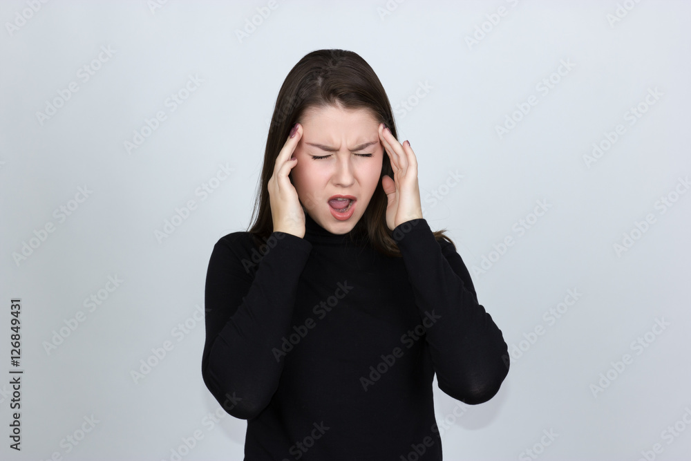 Portrait of a pretty woman in turtleneck sweater over gray background stress and headache having migraine pain Portrait of a pretty woman in turtleneck sweater over gray background stress and headache having migraine pain