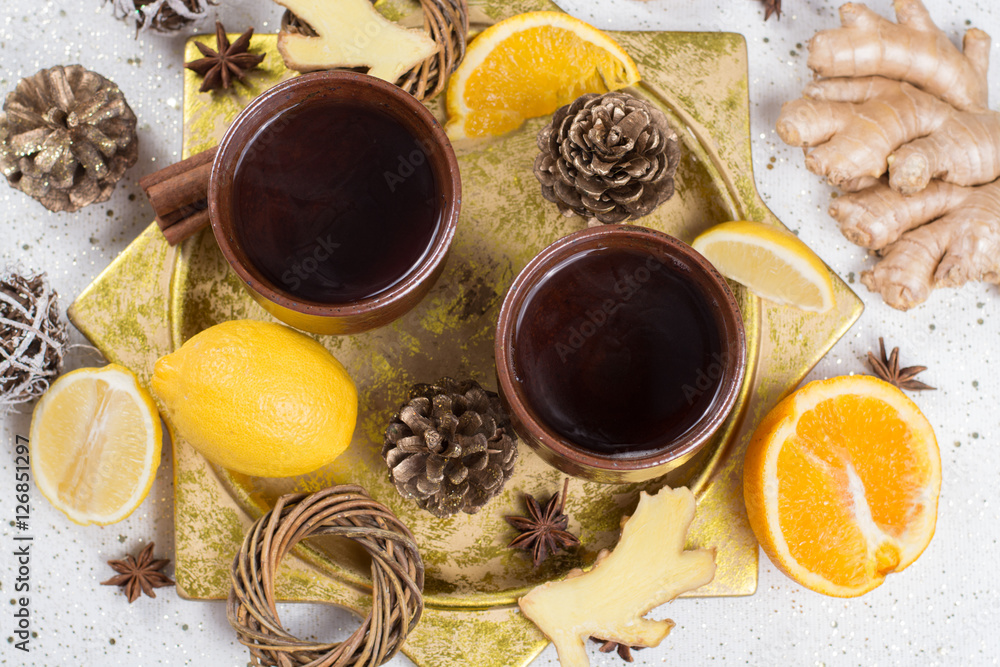 Two clay mugs with christmas winter tea with ginger, anise, sugar, honey Two clay mugs with christmas winter tea with ginger, anise, sugar, honey