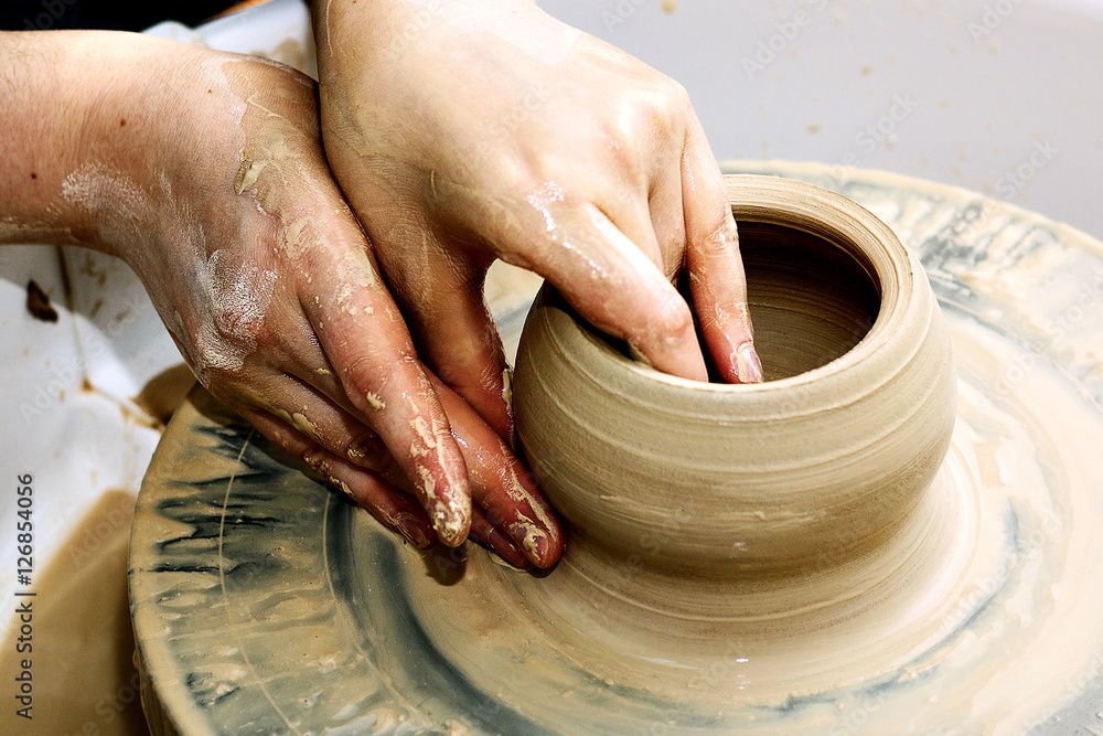 pottery. the teacher teaches the student work on the potter's wheel.