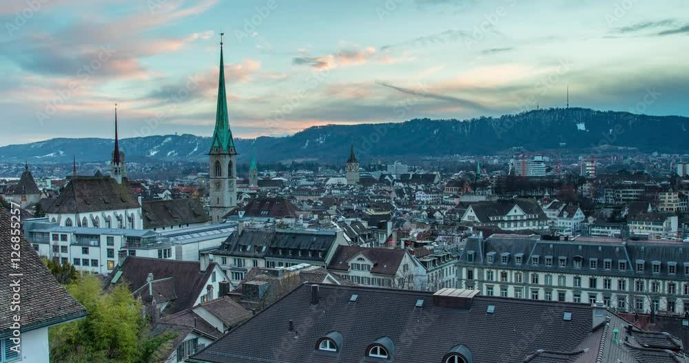 Zurich, Switzerland - view over the roofs of Zurich with church Fraumuenster from Polyterrace of ETH Zurich at sunset - Timelapse with zoom out