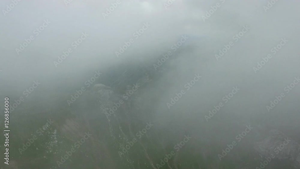 Aerial view of Bucegi mountains reveiling from the clouds, Romania Aerial view of Bucegi mountains reveiling from the clouds, Romania