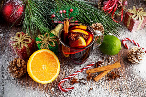 Hot Mulled wine with cinnamon sticks, orange, lime. christmas concept.