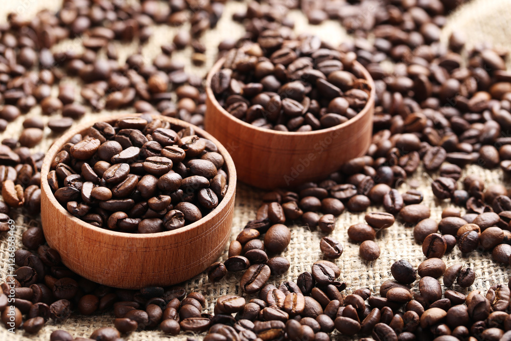 Brown roasted coffee beans in bowl on sackcloth Brown roasted coffee beans in bowl on sackcloth