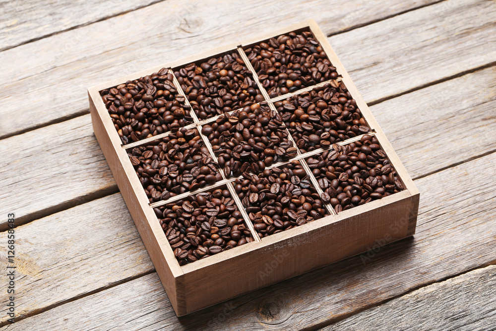 Roasted coffee beans in wooden basket on grey table Roasted coffee beans in wooden basket on grey table