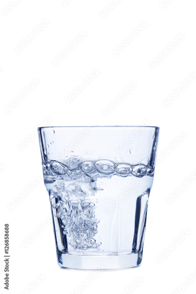 Water pouring in glass isolated on a white Water pouring in glass isolated on a white