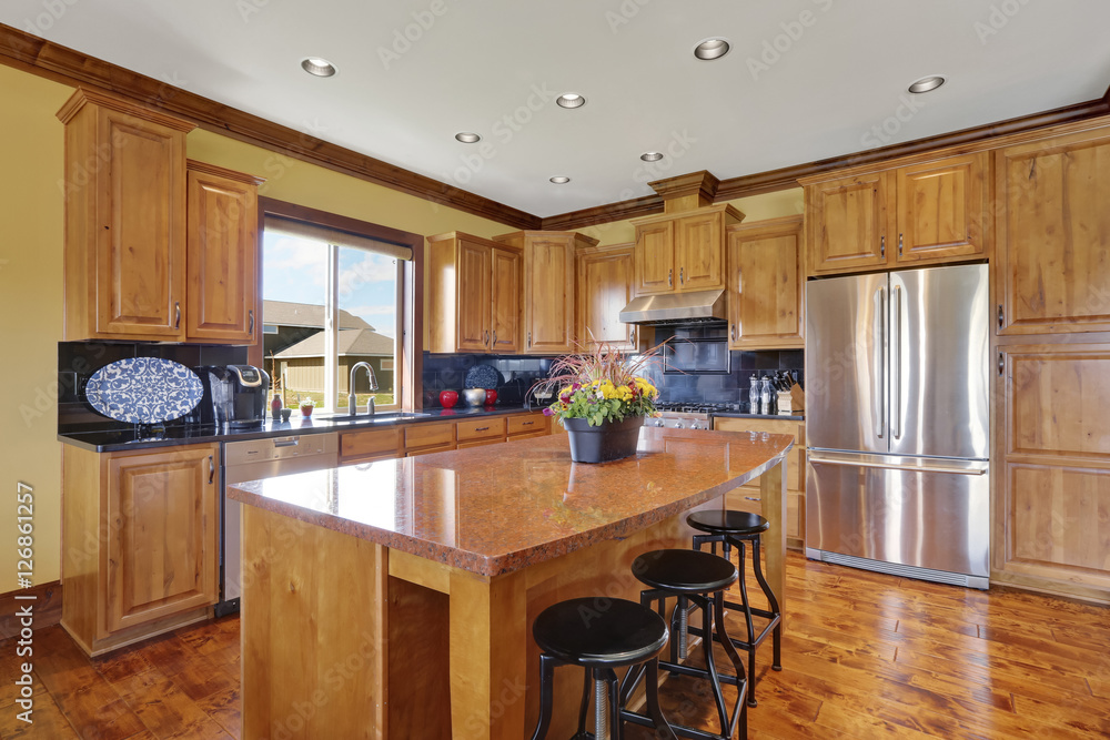 Wooden kitchen interior with an island and steel appliances.
