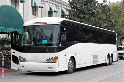 White Tour Charter Bus Parked at Hotel Entrance