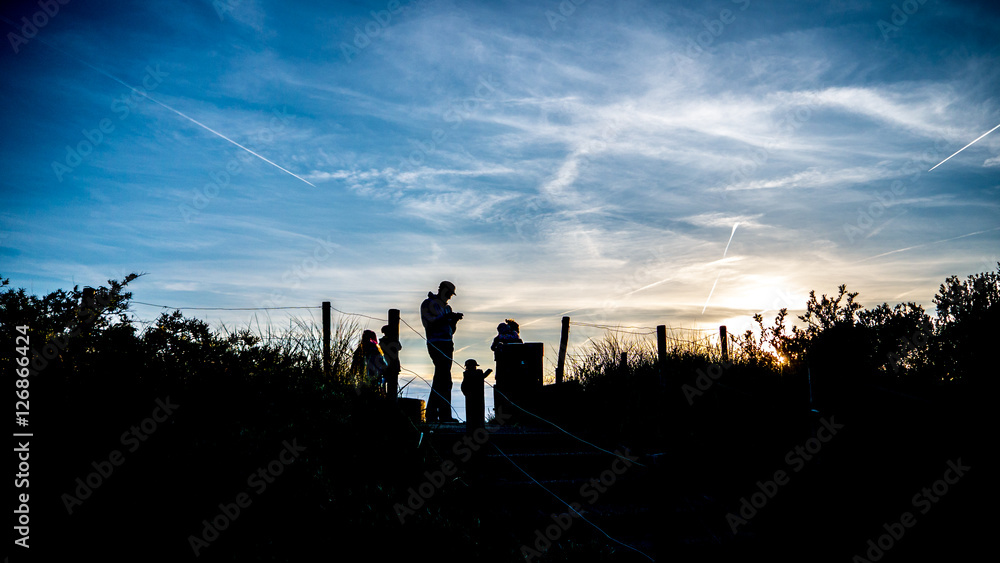 Silhouettes of a family on a hike at sunset