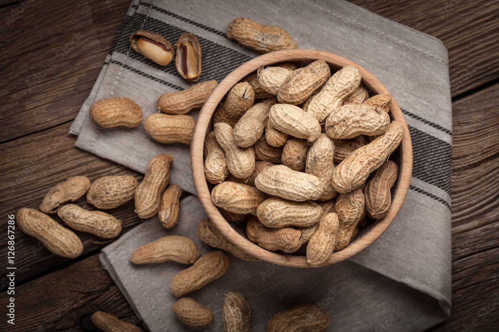 Dried peanuts in wooden bowl.