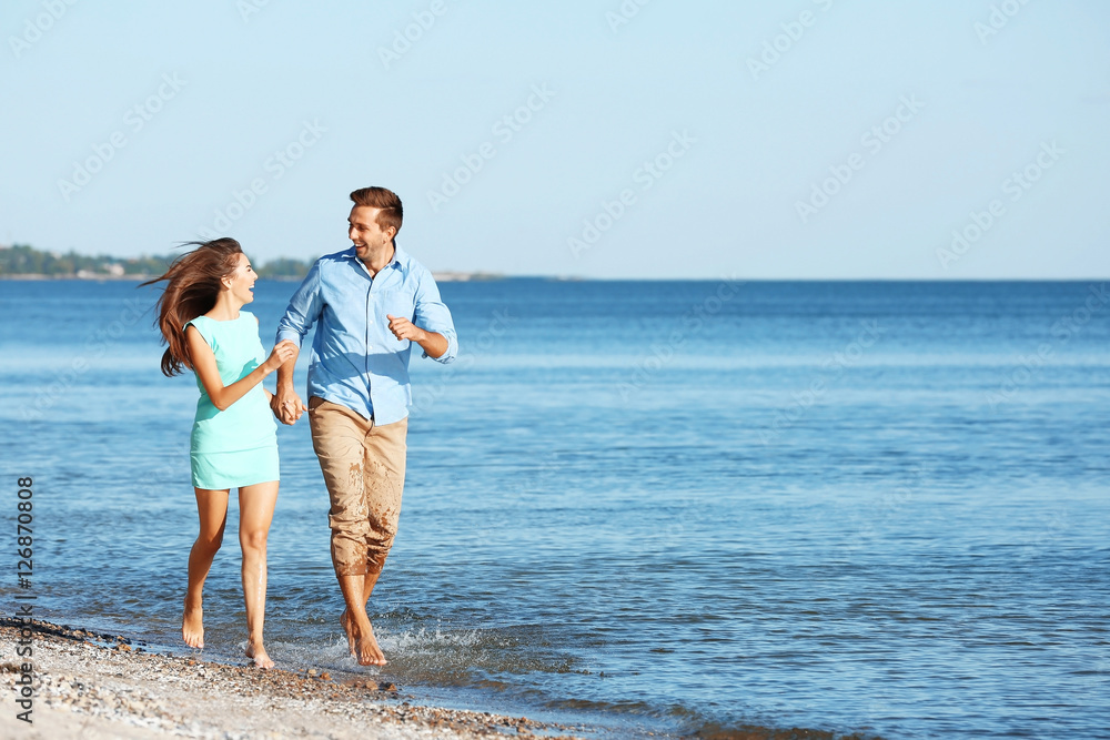 Happy couple in love walking along beach