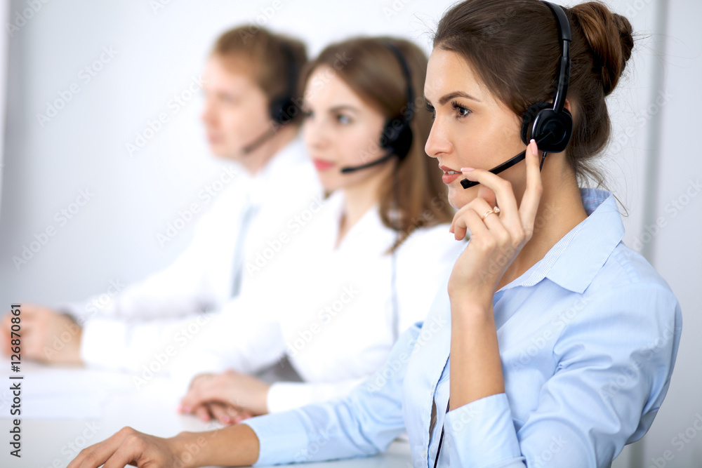 Call center. Focus on beautiful woman in headset Call center. Focus on beautiful woman in headset