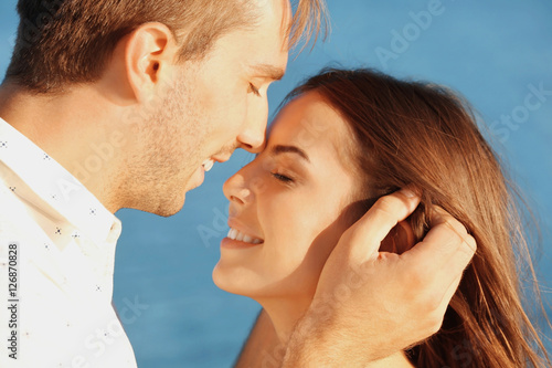 Happy couple kissing on sea...