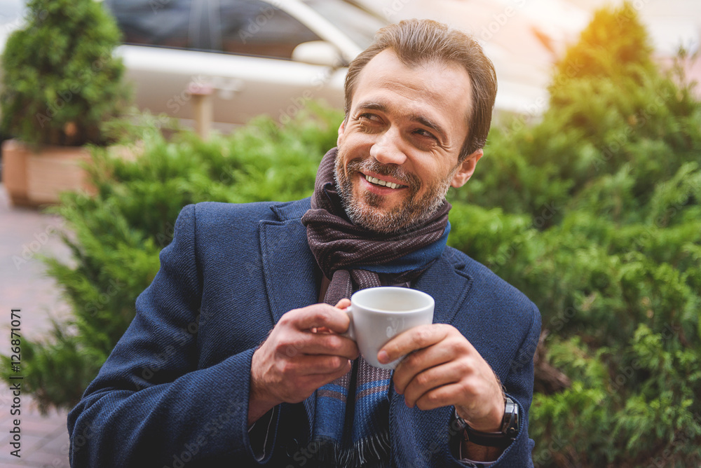 Joyful businessman enjoying hot beverage Joyful businessman enjoying hot beverage