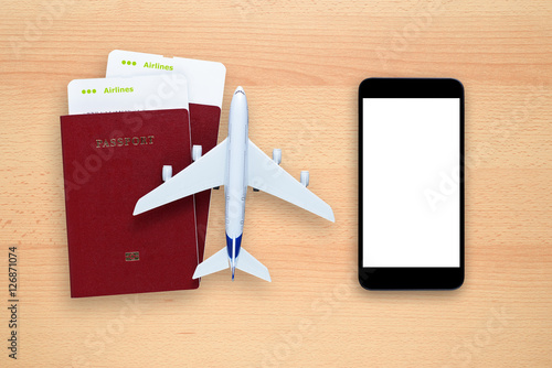 Boarding passes, passports, smartphone and toy aircraft on desk