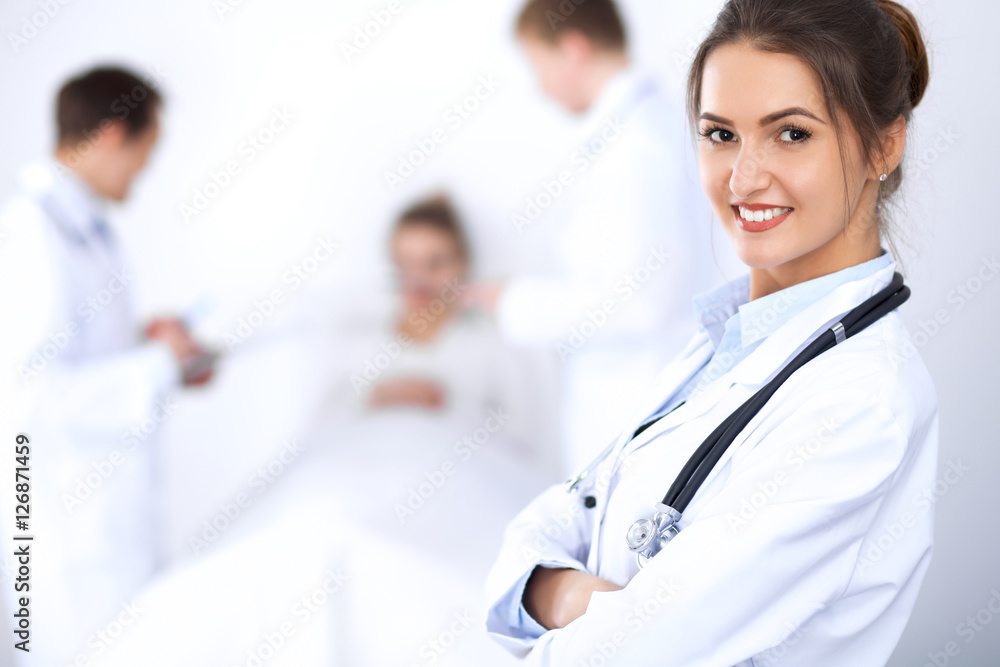 Female doctor smiling on the background with patient in the bed Female doctor smiling on the background with patient in the bed