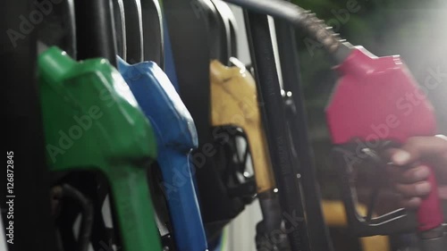 Gasoline or petrol station gas fuel pump nozzle. Filling station. Close-up of a men's hand using a fuel nozzles at a gas station.