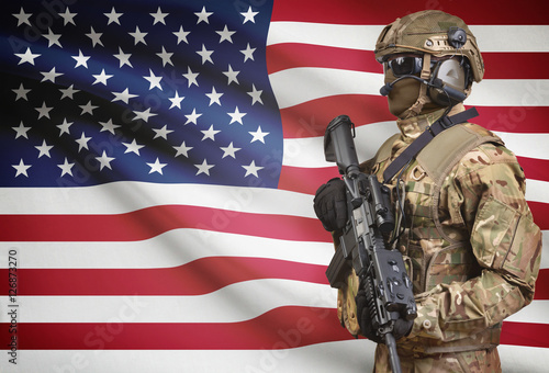Soldier in helmet holding machine gun with flag on background series - United States