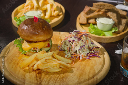 Burgers And Glasses Of Whiskey On Wooden Plates