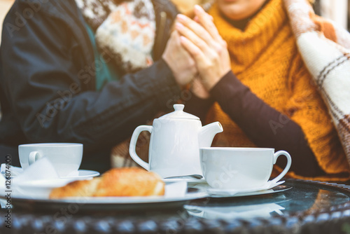 Cute loving couple warming up in cafeteria outside