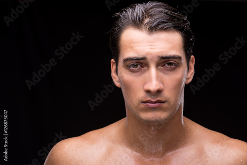 Ripped muscular handsome man on black background