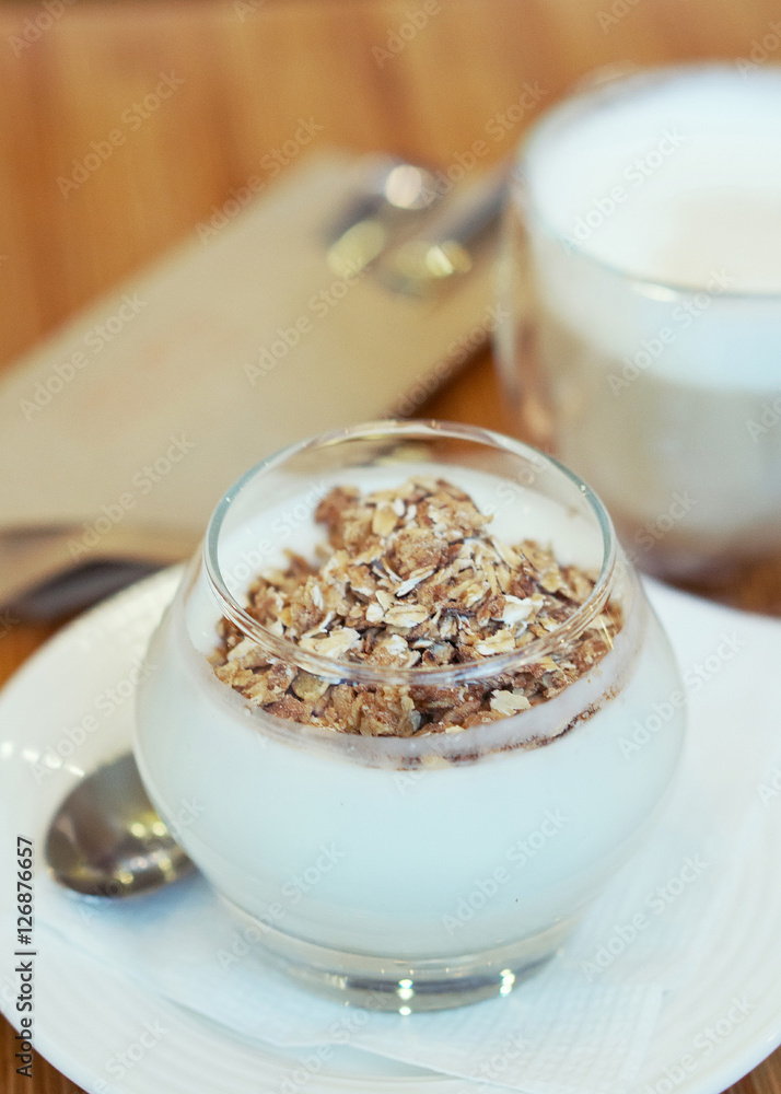 Granola with yogurt and cup of cappuccino; selective focus Granola with yogurt and cup of cappuccino; selective focus